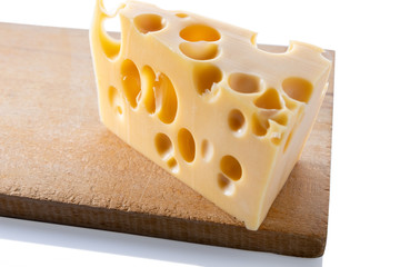 Swiss cheese on a wooden board, isolated close up