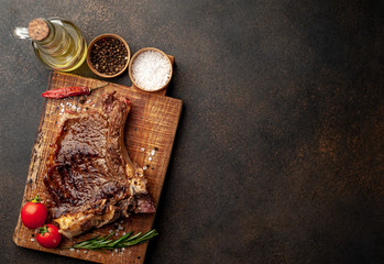 Naklejka na ściany i meble Grilled beef steak with spices on a stone background with copy space for your text.