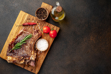 Obraz na płótnie Canvas Grilled beef steak with spices on a stone background with copy space for your text.