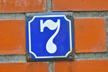 A house number plaque, showing the number seven (7)