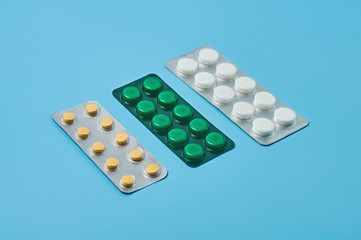 Row of pills in blister packaging lies on blue desk. Concept of healthcare, drug addict or chemical weapon. Close-up
