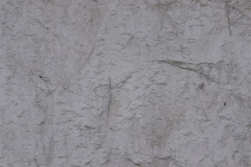 Embossed, matte, plastered gray surface.