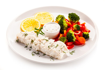 Fish dish - fried fish fillet with vegetables on white background