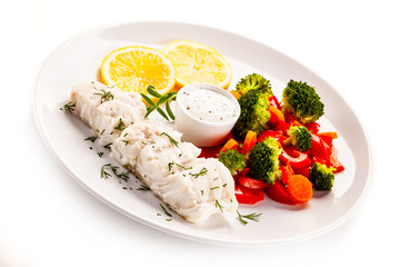 Fish dish - fried fish fillet with vegetables on white background