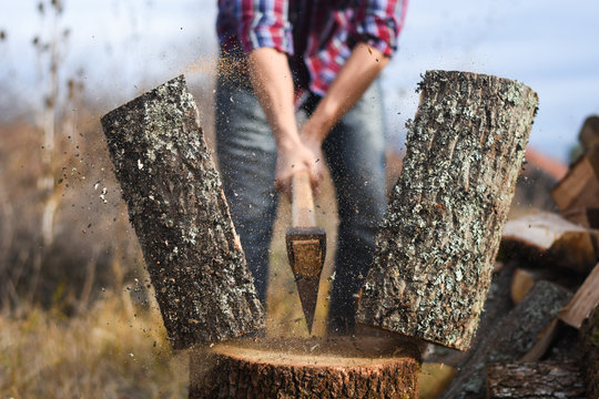 Lumberjack chopping wood for winter, Young man chopping woods with an axe