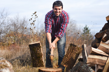 Lumberjack chopping wood for winter, Young man chopping woods with an axe