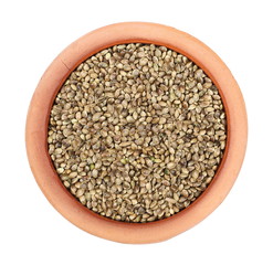 Hemp seeds in clay pot isolated on white background, top view