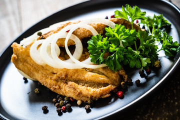 Fish dish - marinated fried fish fillet on wooden table