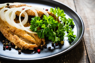 Fish dish - marinated fried fish fillet on wooden table