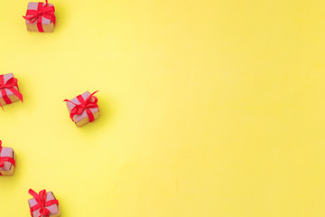 small gift boxes with a red bow on a yellow background top view. Place for text, banner. Pop trend. space for text, free space, copy space