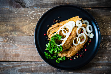 Fish dish - marinated fried fish fillet on wooden table