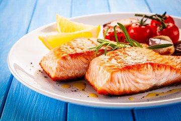 Grilled salmon with vegetables on white plate