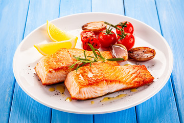 Grilled salmon with vegetables on white plate