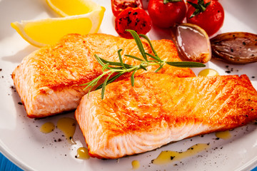 Grilled salmon with vegetables on white plate