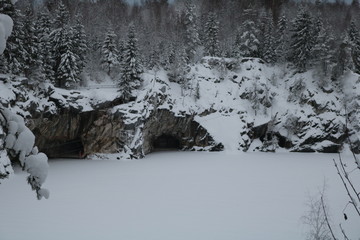 Christmas trees on a steep cliff near the frozen river