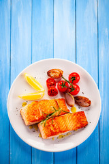 Grilled salmon with vegetables on white plate