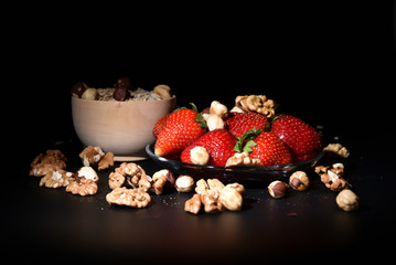 Strawberry, oat flakes and nuts on a black background. Muesli