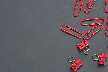 Scattered many binders and clips for paper on dark concrete desk in office, school or home. Space...