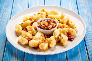 Potato noodles - dumplings on wooden background