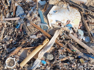 Environmental pollution. Sand beaches polluted with pieces of plastic waste. Micro plastics debris on the beach. Pieces of plastic residues