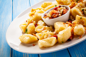 Potato noodles - dumplings on wooden background
