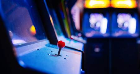 Detail on a Joystick of Old Vintage Arcade Games in a dark room for playing video games - obrazy, fototapety, plakaty
