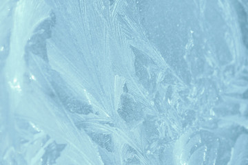 Frosty patterns on the window in winter. Natural abstract background of blue color