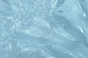 Obraz premium Frosty patterns on the window in winter. Natural abstract background of blue color
