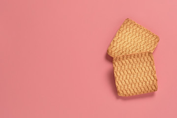 Two whole square cookies lies on pink desk on kitchen. Space for text. Top view