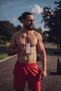 Hipster man eating protein bar after hard workout