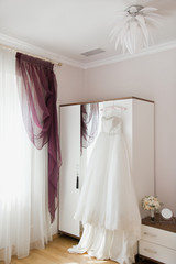 Fototapeta na wymiar Bridal accessories: wedding dress, shoes and bride's bouquet in a loght room. Bride's room in wedding day