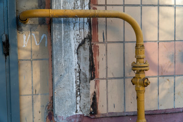Little gas crane on the curved pipe near wall with tiles and ledge. Crane on the pipe allowed to...