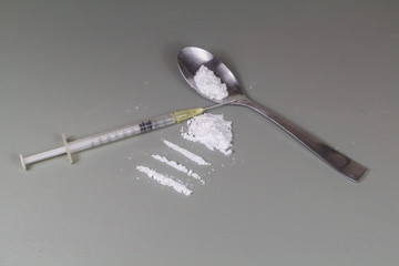 Cocaine lines ready to sniff on a table and syringe