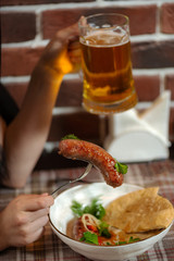 Girl dines in a pub fried sausages