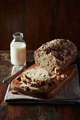 Sliced yeast cake and bottle of milk on rustic wooden background. 