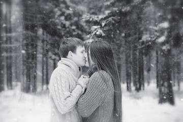 Fototapeta premium A loving couple on a winter walk. Man and woman on a date in the park in winter. Friends in a winter park