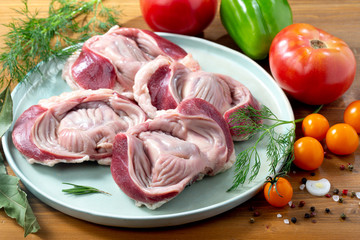 Turkey raw stomach on plate with vegetables 