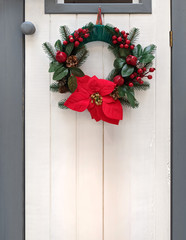 Fototapeta na wymiar Christmas wreath on white door