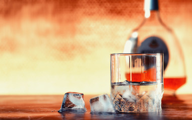 A glass of hard alcohol with ice on a bar counter. Whiskey with soda in a glass. Advertising...