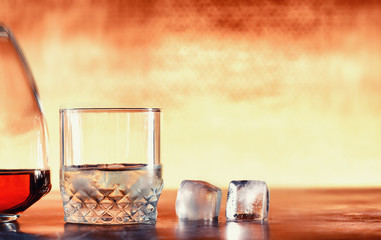 A glass of hard alcohol with ice on a bar counter. Whiskey with soda in a glass. Advertising...
