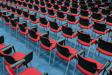 Chairs with a stand for writing. Chairs are arranged for the conference. Red chairs on a blue...