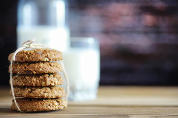 Fresh oatmeal cookies with milk on a texture wood background. Christmas gingerbread cookie and a glass of milk.