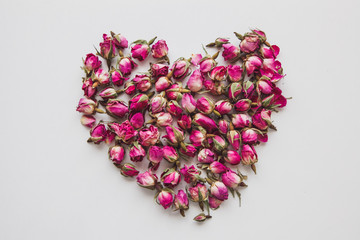 Shape of a heart of pink dried roses on the white background in retro style. St.Valentine's Day concept. Mother's day concept. 