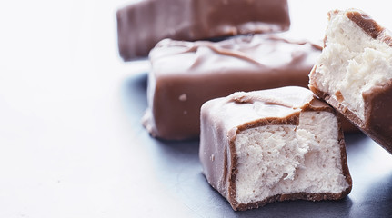 Chocolate bars on a black background in backlight. Chocolate with filling. Sweet sweets for snack and tea.