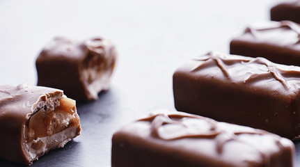 Chocolate bars on a black background in backlight. Chocolate with filling. Sweet sweets for snack and tea.