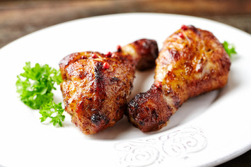 Spicy Chicken Drumsticks with fresh herbs. Brown wooden background. 