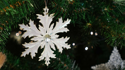 Christmas decorations on the Christmas tree. White snowflake.