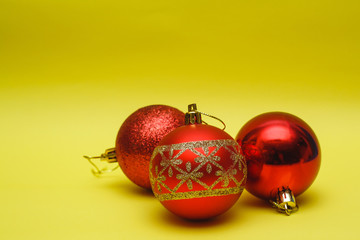 Red toys with fir tree ornaments, yellow background.