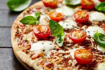  Tasty pizza with cherry tomatoes and fresh basil. Close up.