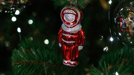 Christmas decorations on the Christmas tree. Red astronaut.